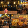 A vintage camper van is illuminated by solar string lights in an outdoor setting.