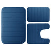 A set of three navy blue plush memory foam bath mats with non-slip backing.
