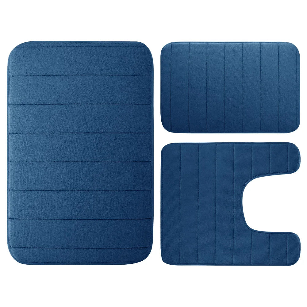 A set of three navy blue plush memory foam bath mats with non-slip backing.