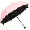 A pink and black floral bloom rain and sun umbrella open, shown from above.