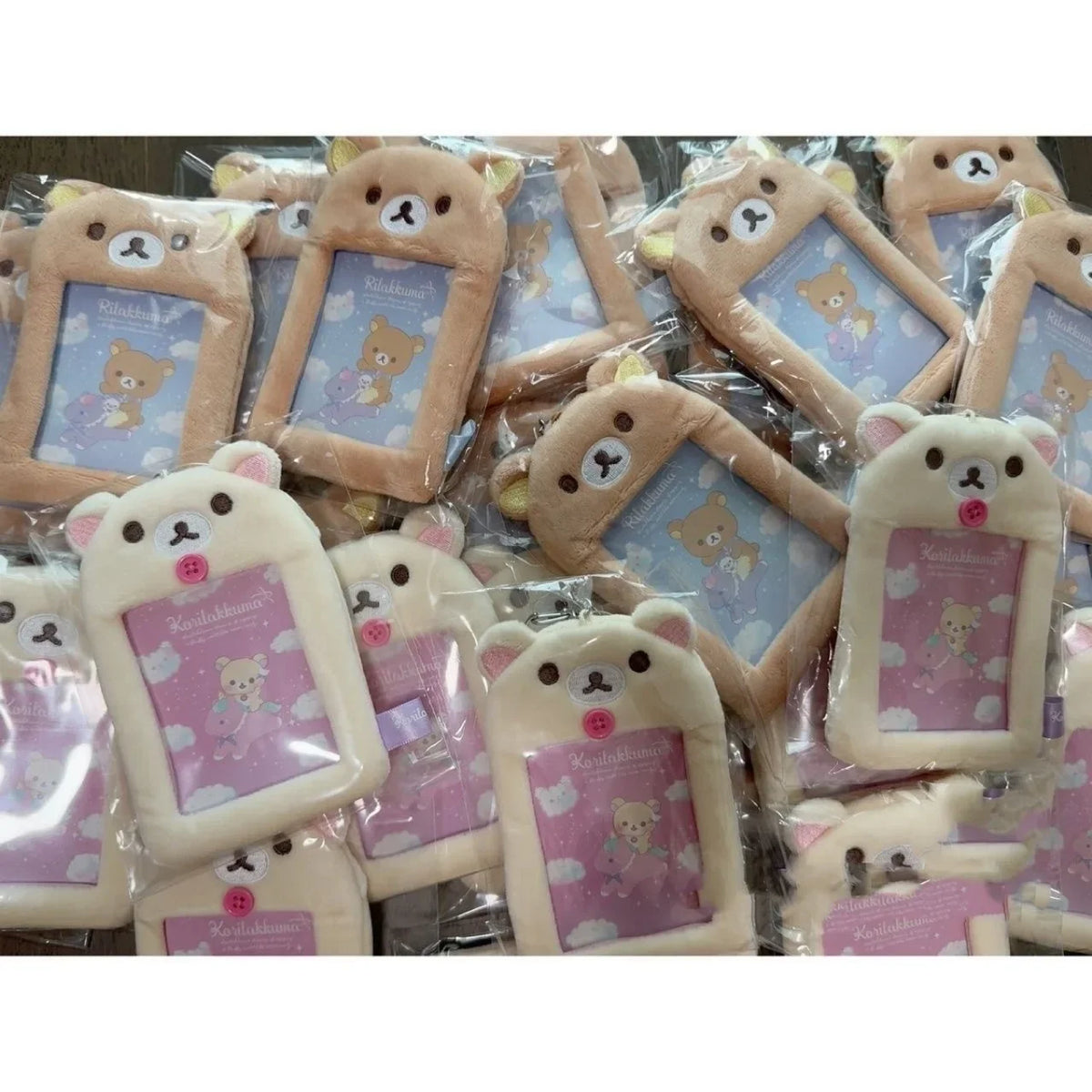 A collection of Rilakkuma plush ID card holders and keychains in various colors and designs.