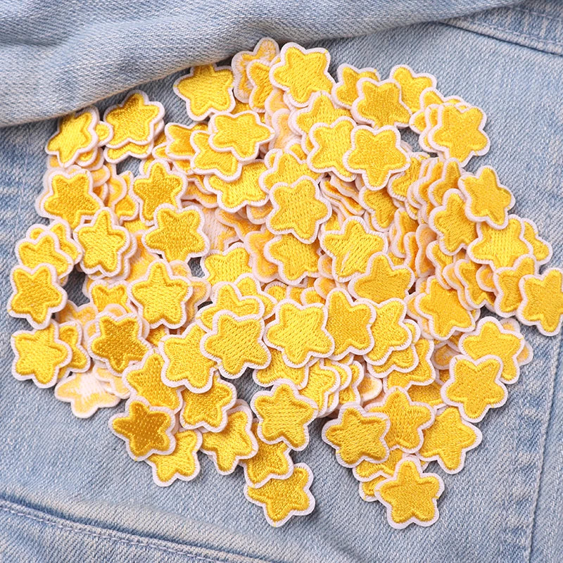 A collection of yellow and cream star-shaped embroidered iron-on patches for DIY clothing decoration.