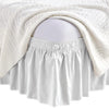 White elastic wrap-around bed skirt with ruffles draped over a pregnant belly