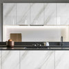 Modern kitchen cabinet featuring white marble finish and under-cabinet lighting.