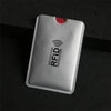 A silver aluminum card holder with an RFID protection symbol on a dark surface.