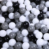 A close-up view of a large pack of colorful plastic balls in various shades of black, white, and gray.