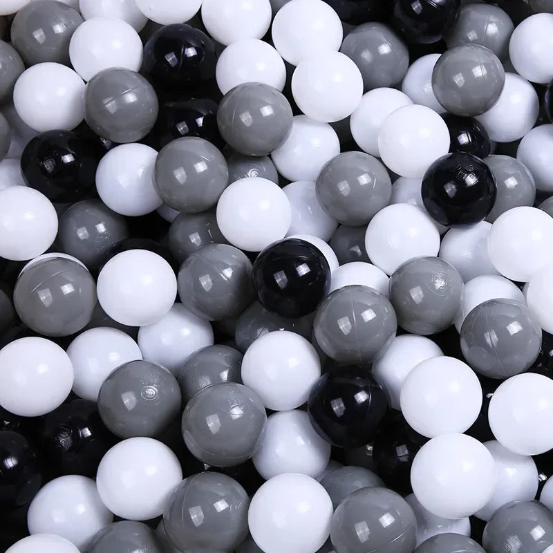 A close-up view of a large pack of colorful plastic balls in various shades of black, white, and gray.