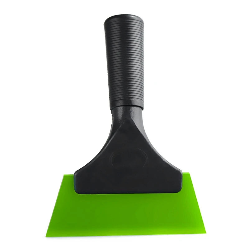 A black car window squeegee with a soft rubber blade resting on a bright green surface.
