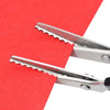 Silver pinking shears cutting into a red piece of fabric