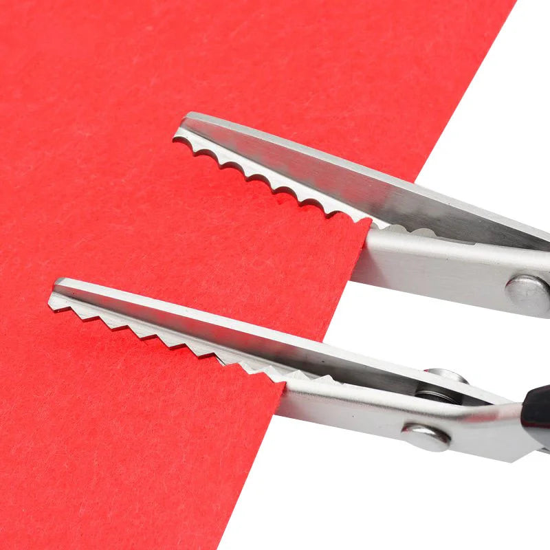 Silver pinking shears cutting into a red piece of fabric