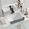 A white ceramic sink with a black faucet and a silicone splash guard resting on a marble countertop.