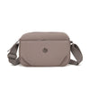 A light taupe nylon crossbody bag with a flap closure and adjustable strap is shown against a white background.