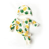 A white and yellow patterned jumpsuit outfit for a baby doll featuring a matching hat.
