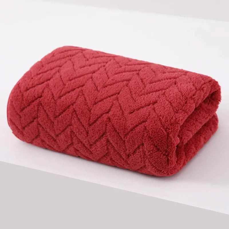A folded, deep red, textured bath towel with a diamond pattern.