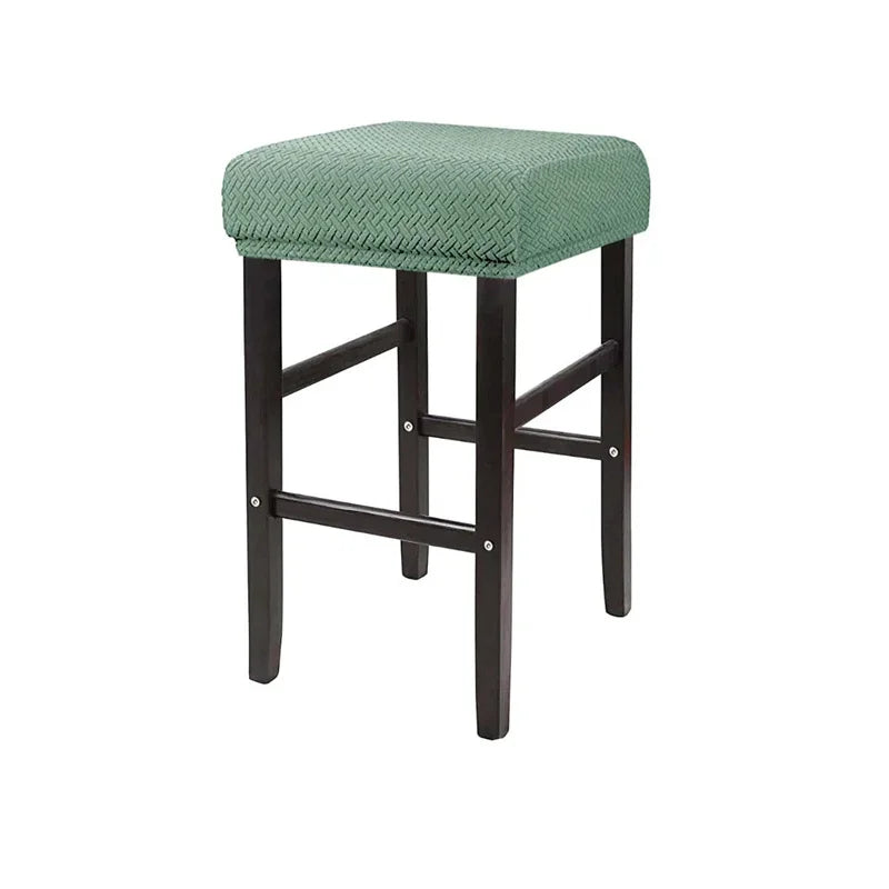 A bar stool featuring a green upholstered seat and dark wood legs.