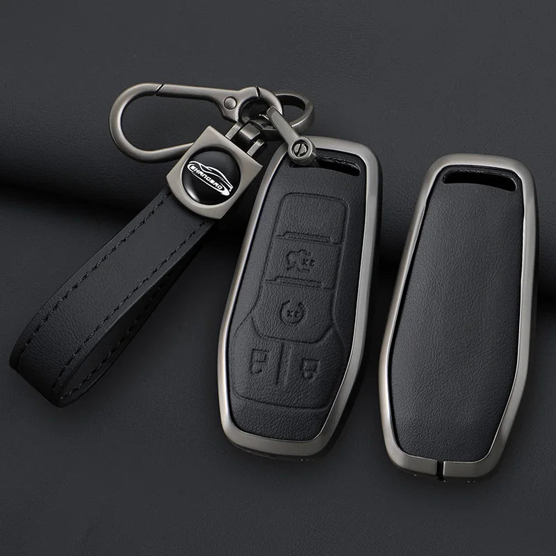 A black key case cover made of zinc alloy and leather with a metal clip attached to a strap.