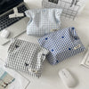 A light blue and white plaid makeup bag with floral embroidery is shown next to a laptop and a white wireless mouse.