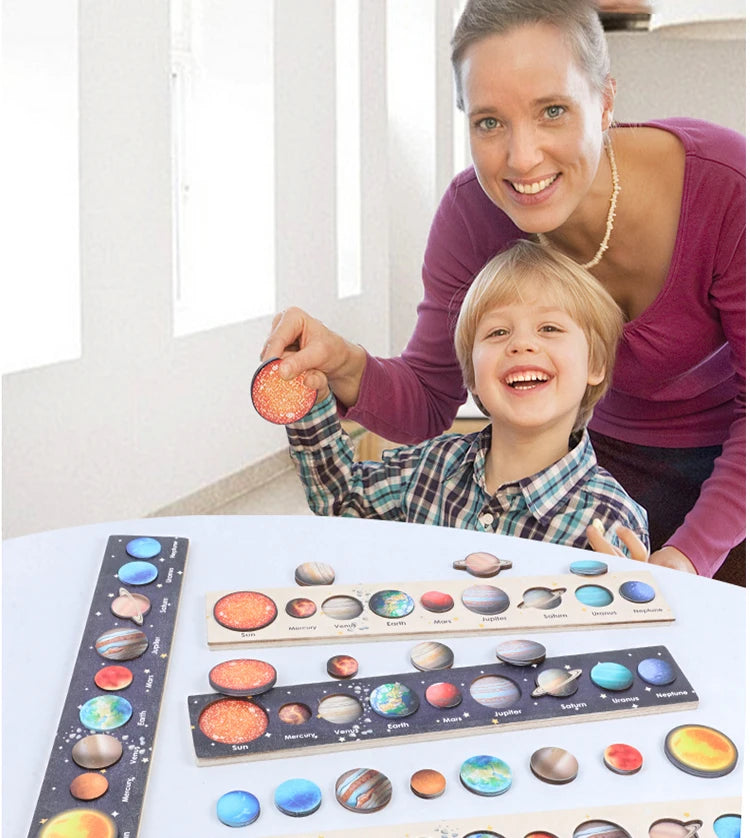 A smiling woman holds a wooden solar system puzzle with colorful planets and moons for children.