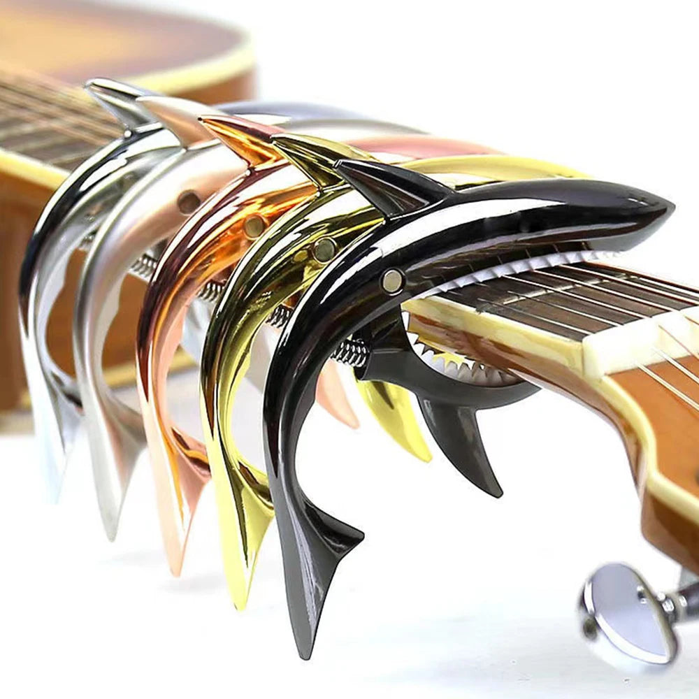 A close-up of a pro-grade zinc alloy guitar capo with various colored and shaped metal pieces.