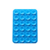 A blue silicone suction pad with multiple circular indentations for phone mounts.