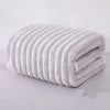 A stack of white microfiber towels rolled into a cylinder, showing their soft texture and ribbed design.