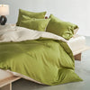 A luxury mulberry silk duvet cover set in olive green and cream tones on a bed.