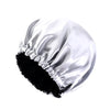 A white satin sleep bonnet with ruffled edges and a black faux fur trim.