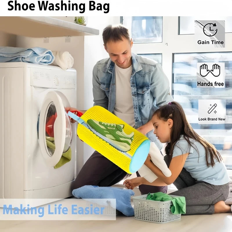 A person is using a yellow shoe washing bag and brush set to clean shoes inside a white washing machine.