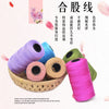 A collection of pink and green yarn spools for knitting and crochet crafts.