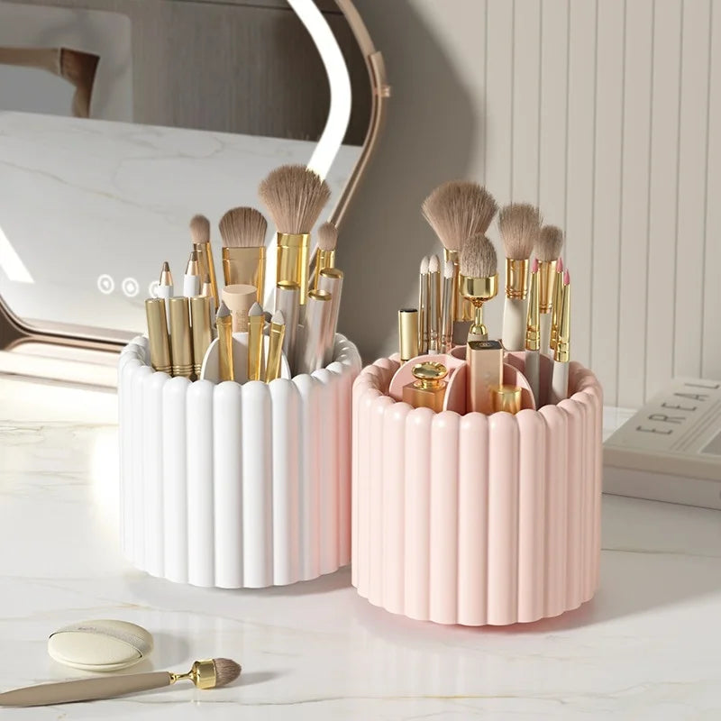 A pink and white cylindrical organizer holding various makeup brushes and tools on a marble surface.