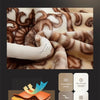 A close-up of a brown and white patterned blanket fabric showing soft textures and plush comfort.