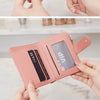 A close-up display of a pink leather compact zippered wallet with card slots and a VIP section being held by hands.