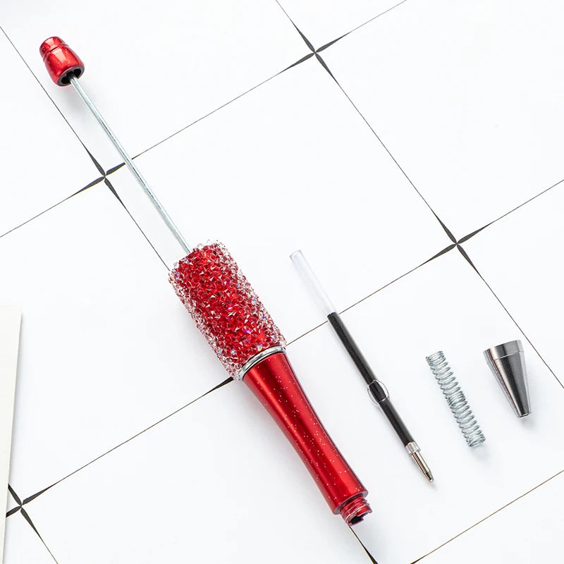 A set of ten red beaded ballpoint pens lying on a white tiled surface.
