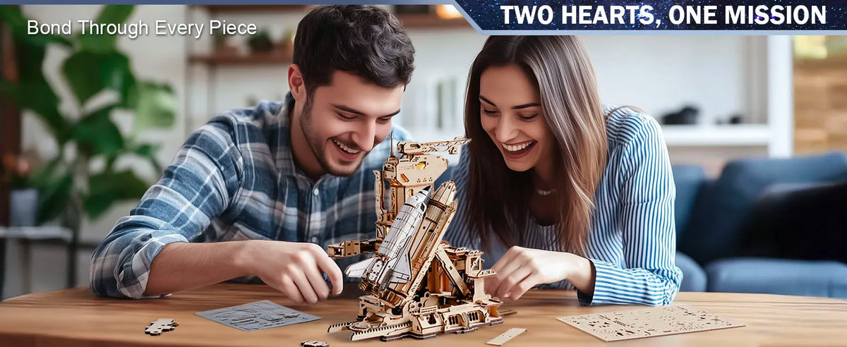 A man and a woman are assembling a detailed wooden space shuttle model kit on a table.