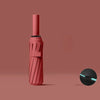 A pink automatic windproof travel umbrella with a black handle and UV protection feature.