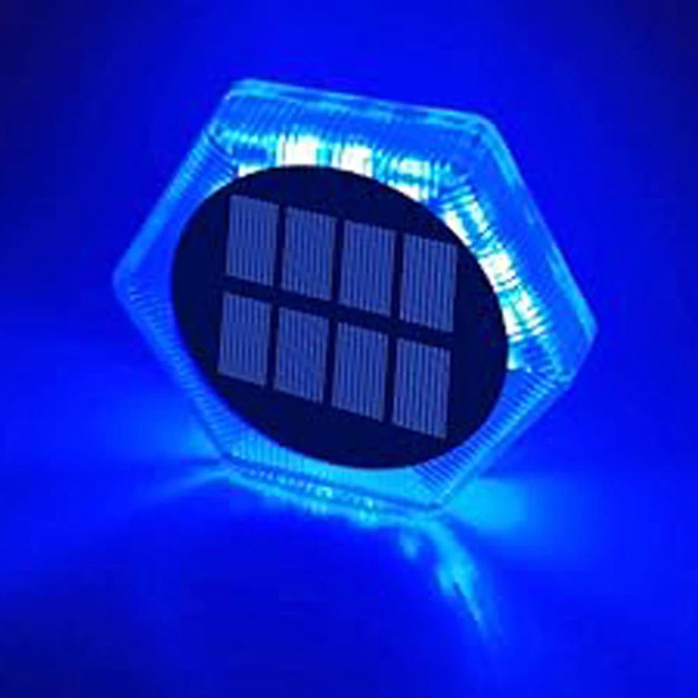 A hexagonal clear light fixture with an oval black panel showing vertical lines, illuminated by blue light.