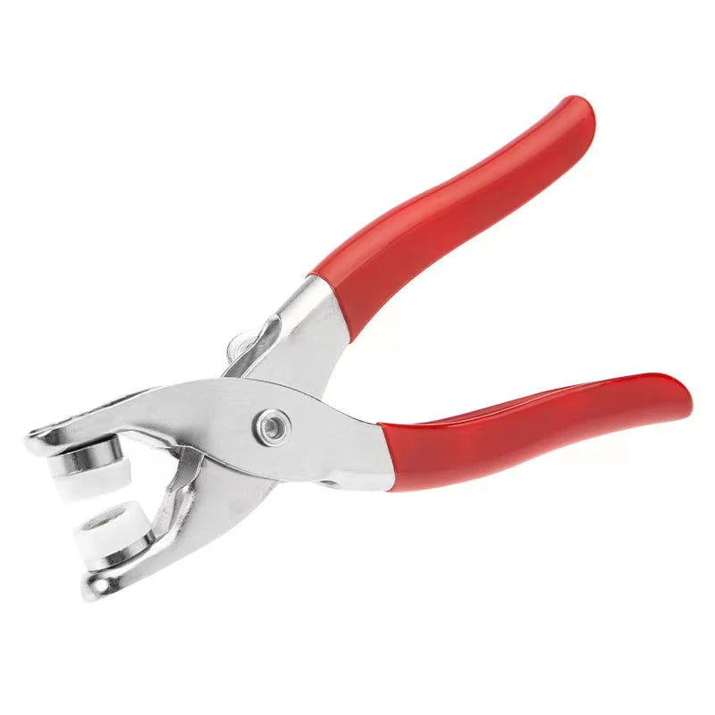 A pair of red-handled pliers with metal buttons for clothes and DIY projects.