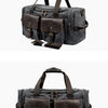 A dark gray canvas duffel bag with brown leather pockets and straps.