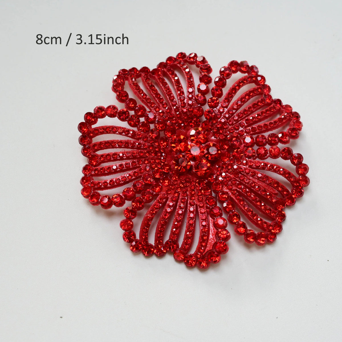 A vibrant red crystal rhinestone flower sew-on patch with intricate petal design.