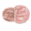 A large pink satin-lined waterproof shower cap with a white leaf pattern.