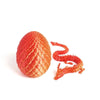 A 3D printed set featuring a textured red dragon egg and an accompanying orange dragon figurine.