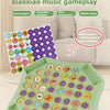 A green plastic board with colorful animal pieces is shown, used for a flipping music game.