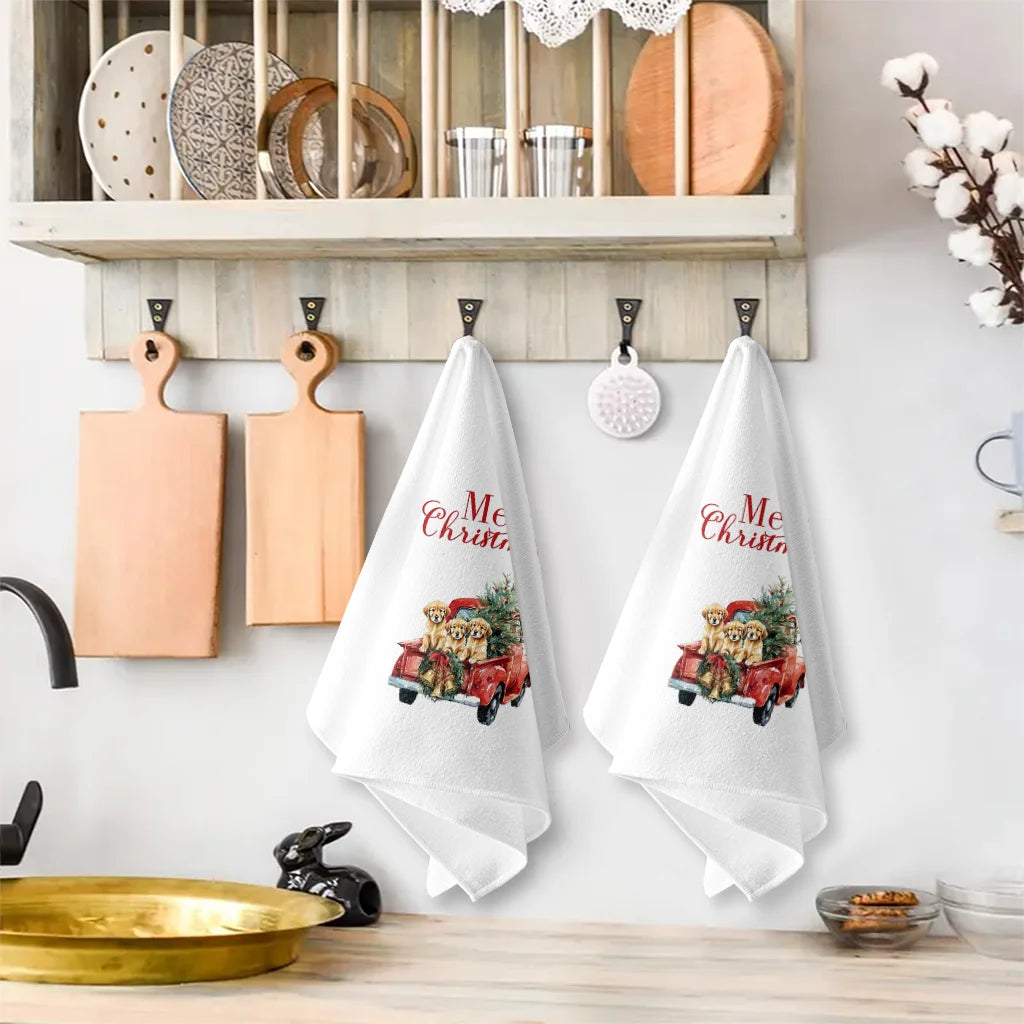 A set of white kitchen towels featuring Christmas themed red pickup trucks and greenery.