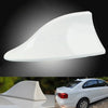 A white shark fin car antenna with FM/AM signal enhancement shown in a close-up view.