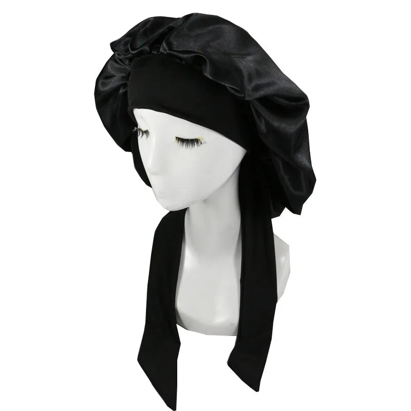 Black satin sleep cap for hair protection displayed on a mannequin.