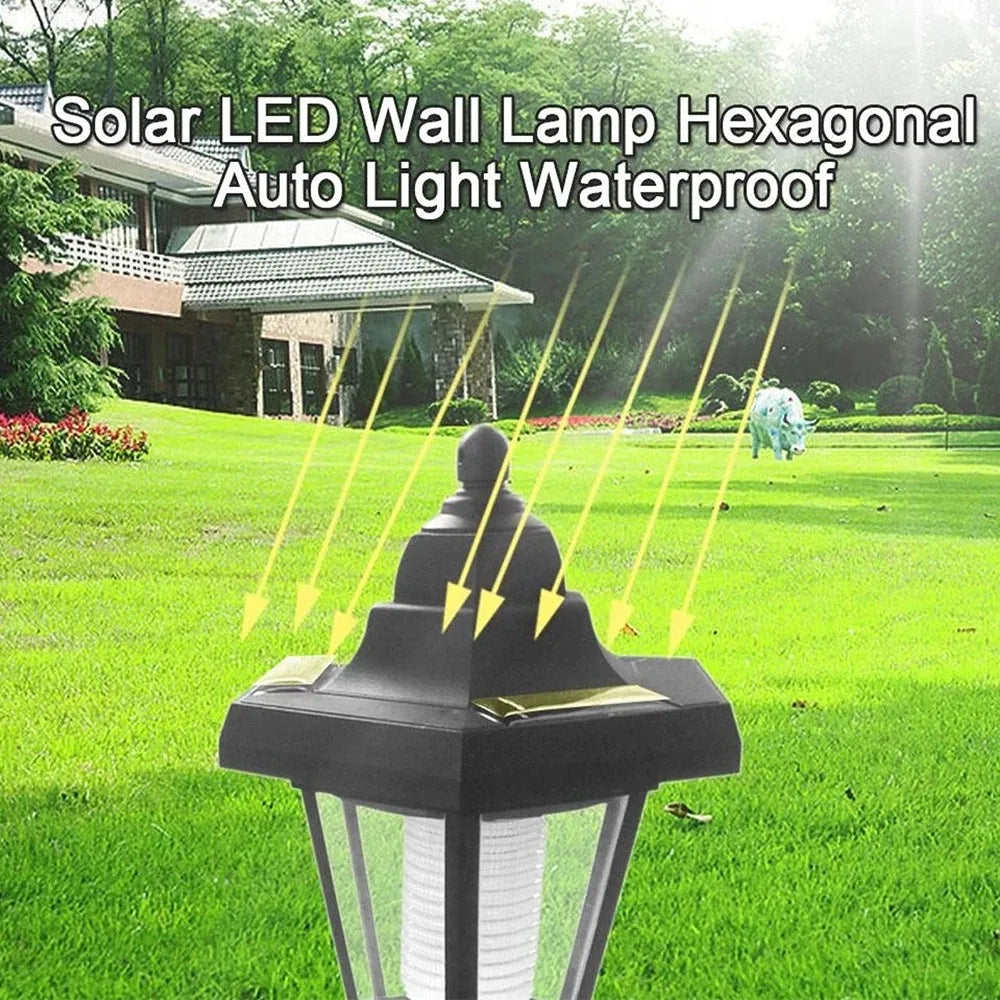 A black hexagonal solar LED wall lamp fixture installed outdoors in a green lawn.
