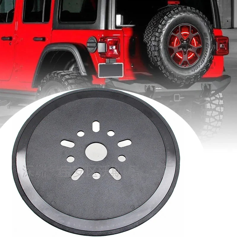 A close-up view of a round black spare tire brake light for a Jeep Wrangler.