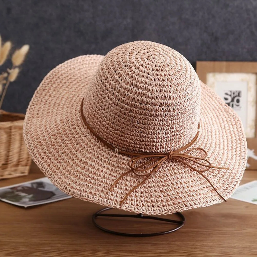Sombrero de paja de ala ancha en color beige natural con textura tejida sobre una superficie de madera.