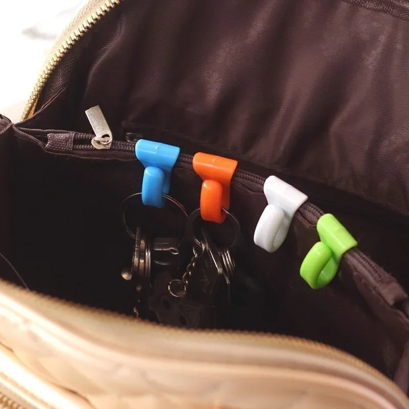 A close-up view inside a dark brown bag showing a set of colorful key holder clips.