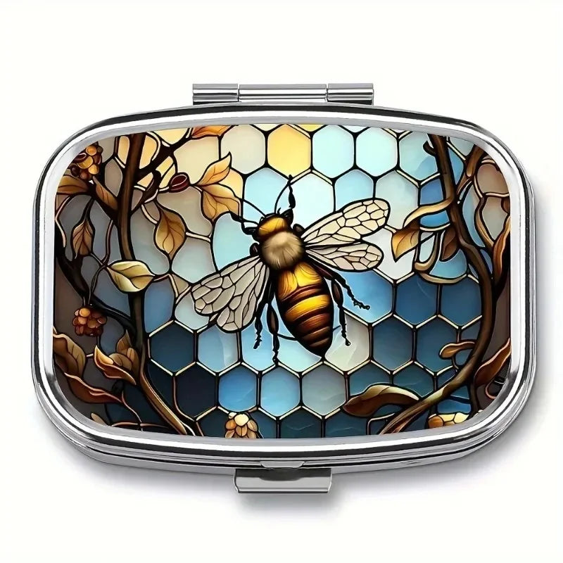 A portable metal pill organizer and jewelry case featuring a detailed illustration of a bee among leaves.